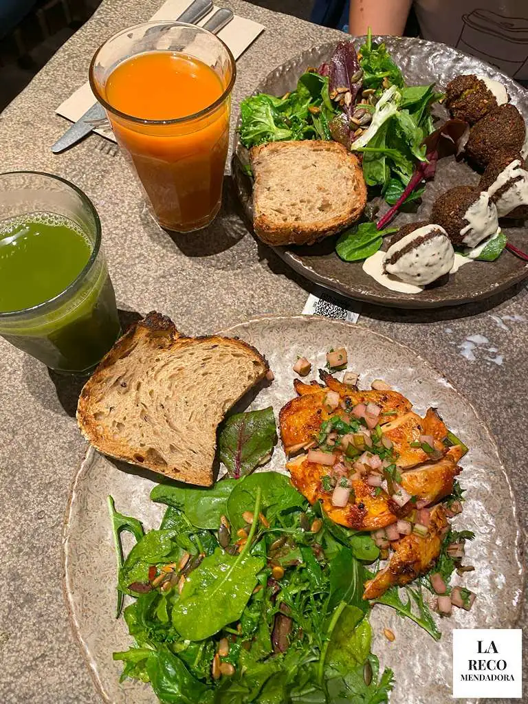 Plato de pollo piri piri y plato de falafel con zumos cold press